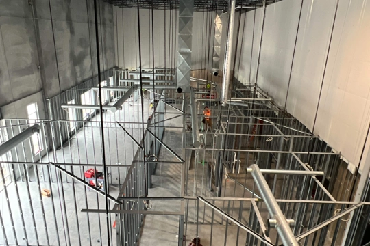 interior of office area under construction with framed out offices and hallway